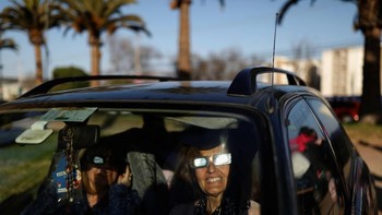 Menyaksikan dari dalam mobil. (Foto: Reuters)