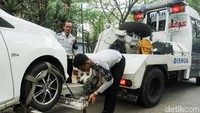 Petugas Dishub menderek mobil yang parkir sembarangan bukan pada tempat yang seharusnya.