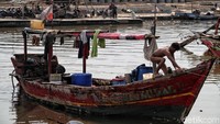 Seorang nelayan beraktivitas di atas kapal.