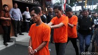 Pelaku tampak memakai baju tahanan oranye.