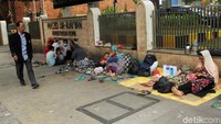 Seorang warga melintas di depan para pencari suaka yang bertahan di depan Masjid Ar-Rayyan, Kementerian BUMN, Jakarta.