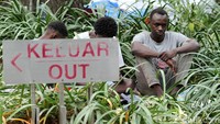 Selain di trotoar, para pengungsi duduk di jalur hijau demi berteduh di bawah pohon. 