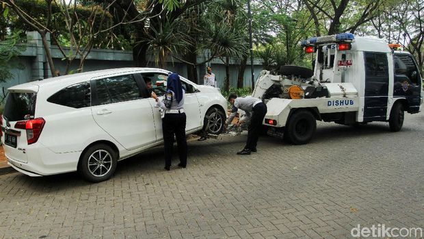 Belasan mobil diderek petugas dari Dinas Perhubungan di Kawasan Gambir dan Kemayoran, Jakarta Pusat, Kamis (4/7/2019).