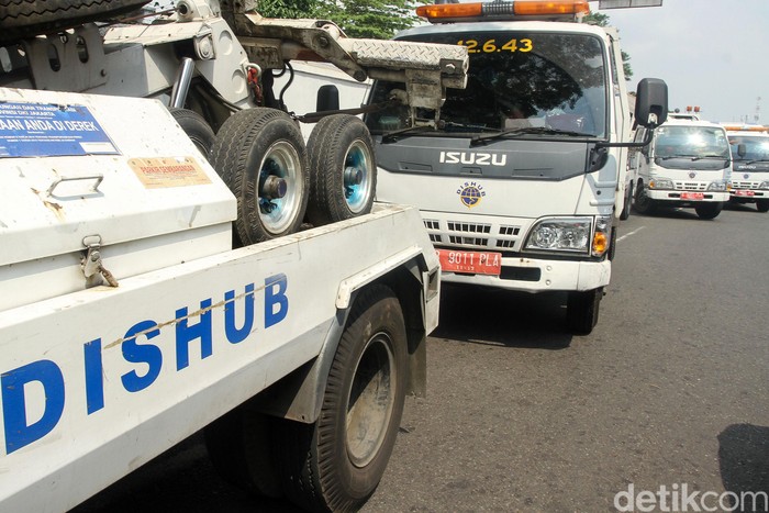 Belasan mobil diderek petugas dari Dinas Perhubungan di Kawasan Gambir dan Kemayoran, Jakarta Pusat, Kamis (4/7/2019).