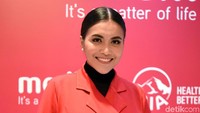 Denada tampil dengan dress merah serta kaus hitam. Pool/Noel/detikFoto.
