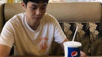 Santai mengenakan kaos putih, ini pose bengong Choi Woo Shik di sebuah tempat makan. Tapi tangannya tetap tak lepas dari minuman soda ya hihihi. Foto: Instagram dntlrdl
