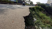 Sejumlah pengendara motor melintas di sisi tanggul kali Bekasi yang longsor, di Jalan Cipendawa, Kota Bekasi, Jumat (05/07/2019).