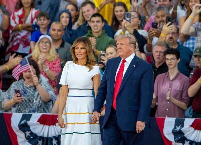 Melania Trump muncul dalam balutan gaun putih Carolina Herrera dan sepasang heels Louboutin berwarna fuchsia. Gaun seharga Rp 17 juta itu dipermanis dengan detail pita di bahu dan garis-garis pada bagian rok. (Foto: Getty Images)