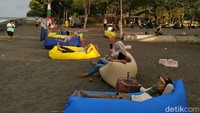 Ada beberapa wisatawan yang sedang asyik makan bersama di pinggir pantai dan mandi di pantai ini (Ardian Fanani/detikcom)  