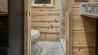 Toilet rumah ini sangat mungil namun sudah dilengkapi dengan shower dan kabinet penyimpanan peralatan mandi. Istimewa/Dok. Inhabitat.
