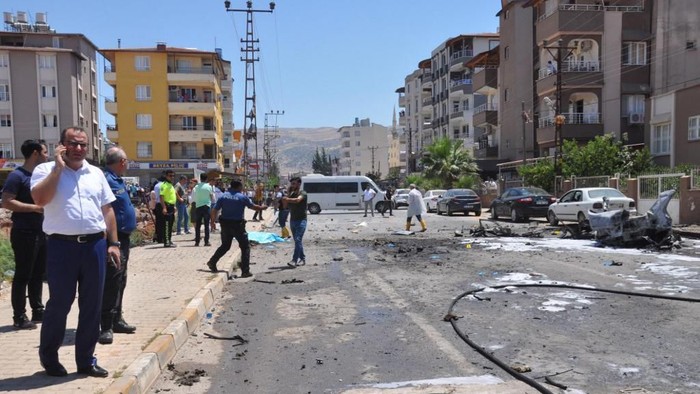 Security and forensic officials work at the site after a car blast in Reyhanli, Turkey, on July 5, 2019. - Two people were killed on July 5, 2019 after a car blast in the Turkish town of Reyhanli close to the Syrian border, state media reported. The blast took place less than a kilometre from the Reyhanli district governors office. (Photo by - / Demiroren News Agency (DHA) / AFP) / Turkey OUT
