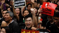 Dalam aksi pada Minggu (7/7) waktu setempat, para demonstran berkumpul di sekitar stasiun West Kowloon yang menghubungkan Hong Kong dengan China daratan. Mereka meneriakkan slogan-slogan yang sebagian menggunakan bahasa Mandarin, agar wisatawan asal China daratan bisa memahami seruan mereka. REUTERS/Thomas Peter.