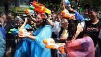 Ada pula warga yang ikut serta dalam perang pistol air dengan menggunakan jas hujan. Chung Sung-Jun/Getty Images.
