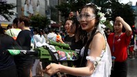 Salah seorang warga berpakaian unik dengan membawa serta pistol air dalam perayaan festival air di Kota Seoul, Korea Selatan. Chung Sung-Jun/Getty Images.