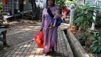 Senyum ceria warga usai membeli sembako murah.