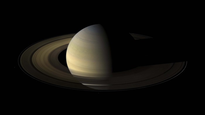 This NASA handout image obtained October 19, 2009 shows Saturn during an equinox captured by the robot explorer Cassini. The images comprising the mosaic, taken over about eight hours, were extensively processed before being joined together. With no enhancement, the rings would be essentially invisible in this mosaic. To improve their visibility, the dark right half of the rings has been brightened relative to the brighter left half by a factor of three, and then the whole ring system has been brightened by a factor of 20 relative to the planet. So the dark half of the rings is 60 times brighter, and the bright half 20 times brighter, than they would have appeared if the entire system, planet included, could have been captured in a single image.The images were taken on August 12, 2009, beginning about 1.25 days after exact equinox, using the red, green and blue spectral filters of the wide angle camera and were combined to create this natural color view. The images were obtained at a distance of approximately 526,000 miles from Saturn and at a Sun-Saturn-spacecraft, or phase, angle of 74 degrees. Image scale is 31 miles per pixel. AFP PHOTO/NASA/JPL/SPACE/RESTRICTED TO EDITORIAL USE (Photo by HO / NASA / AFP)