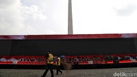 Sejumlah petugas nampak membersihkan area di sekitar panggung acara HUT Bhayangkara ke-73 di kawasan Monas, Jakarta.