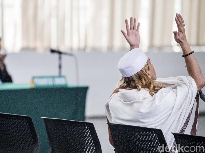 Terdakwa kasus dugaan penganiayaan terhadap remaja Bahar bin Smith memegang bendera merah putih seusai menjalani sidang putusan di gedung Arsip dan Perpustakaan, Bandung, Jawa Barat, Selasa (9/7/2019). Majelis hakim menjatuhi hukuman kepada Bahar bin Smith tiga tahun penjara, denda Rp50 juta dan subsider satu bulan kurungan. ANTARA FOTO/M Agung Rajasa/foc.