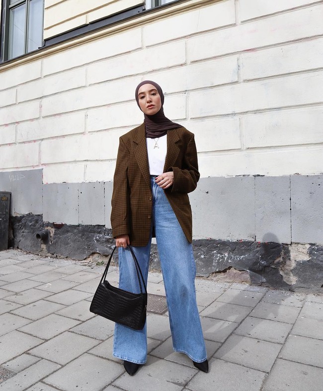 Outfit berwarna agak cerah yang sering terlihat di foto-foto gaya busananya bisa jadi adalah celana denim. Gaya Imane memadukan celana kulot denim dengan blazer kotak-kotak cokelat dan kaus putih ini bisa jadi inspirasi untuk tampilan casual - formal ke kantor. Foto: Instagram @fashionwithfaith