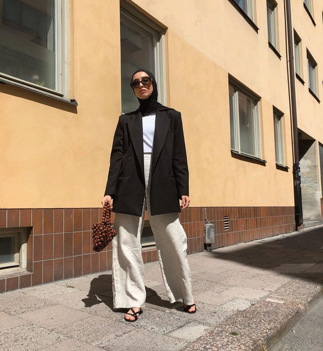 Memakai warna netral tak selalu membosankan. Kamu bisa memberikan sentuhan berbeda pada tampilan kamu dengan menambahkan item yang unik. Seperti yang dilakukan Imane ini dengan menenteng tas bola-bola kayu. Foto: Instagram @fashionwithfaith