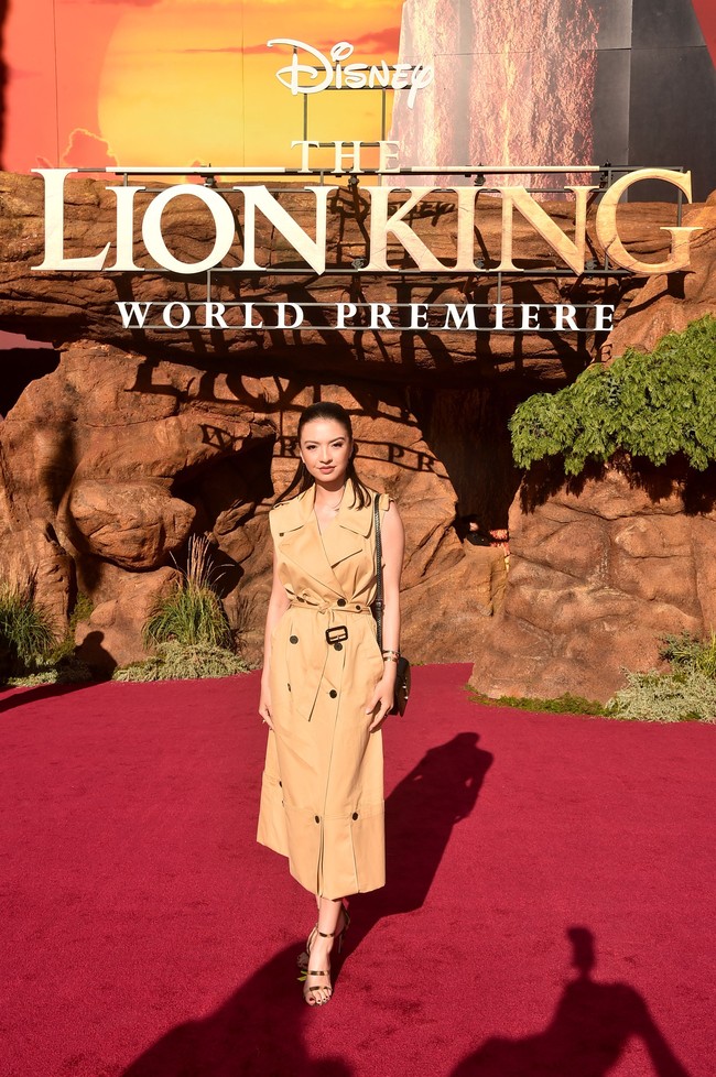 Menyesuaikan dengan dress code acara, yakni Savannah Chic, Raline menebar pesonannya dalam balutan dress bergaya coat. Warna coklatnya merefleksikan baju-baju safari. (Foto: Alberto E. Rodriguez/Getty Images for Disney)