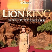 Menyesuaikan dengan dress code acara, yakni Savannah Chic, Raline menebar pesonannya dalam balutan dress bergaya coat. Warna coklatnya merefleksikan baju-baju safari. (Foto: Alberto E. Rodriguez/Getty Images for Disney)