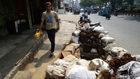 Seorang warga melintas di trotoar yang sebagian sisinya tak dapat digunakan karena terdapat proyek galian di kawasan Depok, Jawa Barat.