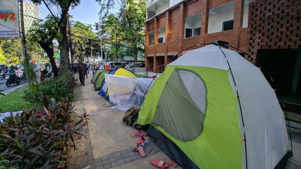 Tenda-tenda pencari suaka terpasang di trotoar.