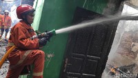 Mereka menyemprotkan air ke bangunan yang terbakar.