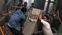 Warga mengevakuasi barang-barang yang tersisa.