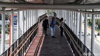 Sejumlah jurnalis melintas di atas skybridge di Stasiun LRT Velodrome,  Jakarta Timur.