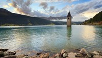 Bangunan desa di sana pun ada beberapa yang tenggelam. Salah satunya menara dengan lonceng gereja. Kamu bisa melihat menara ini di tengah danau. (iStock)