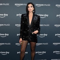 Dua Lipa tampil edgy dalam balutan gaun bersiluet blazer dengan sequin yang berkilauan. Untuk bawahan, ia terlihat tak memakai apapun kecuali stocking bermotif polkadot. (Foto: Jamie McCarthy/Getty Images)