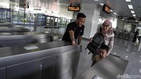 Seorang petugas bersiaga untuk membantu warga masuk ke ruang tunggu LRT.