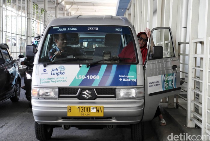 Seorang warga menaiki mobil angkot Jak Lingko dengan nomor Jak 10 di kawasan sky bridge Tanah Abang,  Jakarta Pusat,  Jumat (12/7). Program Jak Lingko angkutan kota Jenis Mikrotrans ber AC yang dicanangkan oleh Pemda Prov DKI Jakarta dengan pengusaha angkutan kota, merupakan terobosan yang perlu diapresiasi. Saat ini angkot Jak Lingko yang memiliki AC tersebut baru memiliki 5 armada dan melayani rute Tanah Abang-Kota.