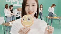 Dengan senyum lebar, Mina berpose mirip seperti cookie yang dipegang di tangannya. Foto: Instagram @minajype