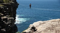 Slacklining atau berjalan di atas tali ini menjadi olahraga ekstrem karena banyak yg melakukan itu di tengah-tengah jurang. Cameron Spencer/ Getty Images.