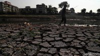Warga memancing di sisa aliran sungai yang hampir mengering.