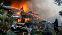 Petugas pemadam kebakaran yang sedang melenyapkan api dari rumah-rumah yang terbakar di Filipina. (Reuters).