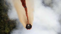 Petugas pemadam kebakaran Indonesia memadamkan kebakaran hutan dengan menumpahkan air dari helikopter. (Reuters).