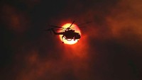 Perjalanan helikopter milik petugas pemadam kebakaran menuju kebakaran yang terjadi di Yunani. (Reuters).