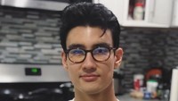 Pose Alex di dapur ini bikin salah fokus ya. Ia nampak santai dengan kaos putih sambil menggendong anjing. Foto: Instagram alexlandi7