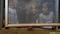 Anak-anak mengobrol di balik jendela.