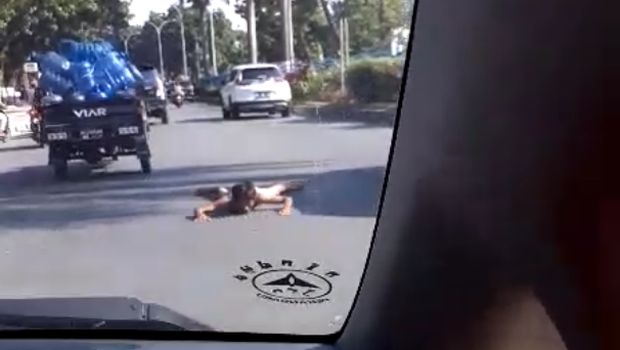 Selain naik kap mobil, pria diduga gila itu juga tidur di tengah jalan