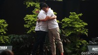 Sandiaga dan Erick Thohir berpelukan di atas panggung.