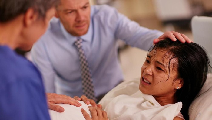 In the Hospital, Close-up Shot of a Shouting Woman in Labor Pushing Hard to Give Birth. Modern Maternity Hospital with Professional Midwives.