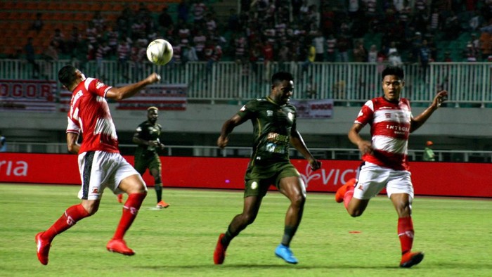 Pesepak bola Tira Persikabo Osas Saha (tengah) dikawal ketat kedua pesepak bola Madura United pada laga Liga 1 2019 di Stadion Pakansari, Bogor, Jawa Barat, Jumat (12/7/2019). Dalam babak pertama Tira Persikabo unggul 1-0.  ANTARA FOTO/Yulius Satria Wijaya/nz.