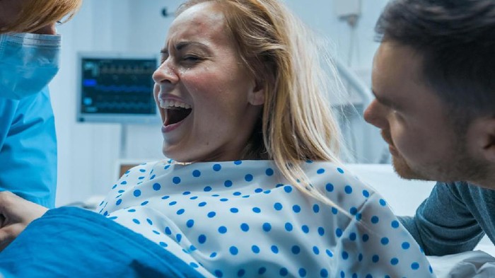 1038800184 In the Hospital, Close-up Shot of a Shouting Woman in Labor Pushing Hard to Give Birth. Modern Maternity Hospital with Professional Midwives.