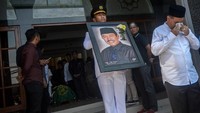 Bupati Bandung Barat Aa Umbara (kanan) menyeka air matanya di dekat foto almarhum mantan Bupati Bandung Barat Abubakar setelah disalatkan di Masjid Agung Lembang, Kabupaten Bandung Barat, Jawa Barat, Sabtu (13/7/2019). ANTARA FOTO/Raisan Al Farisi.