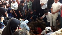 Jenazah dimasukan ke liang lahat.